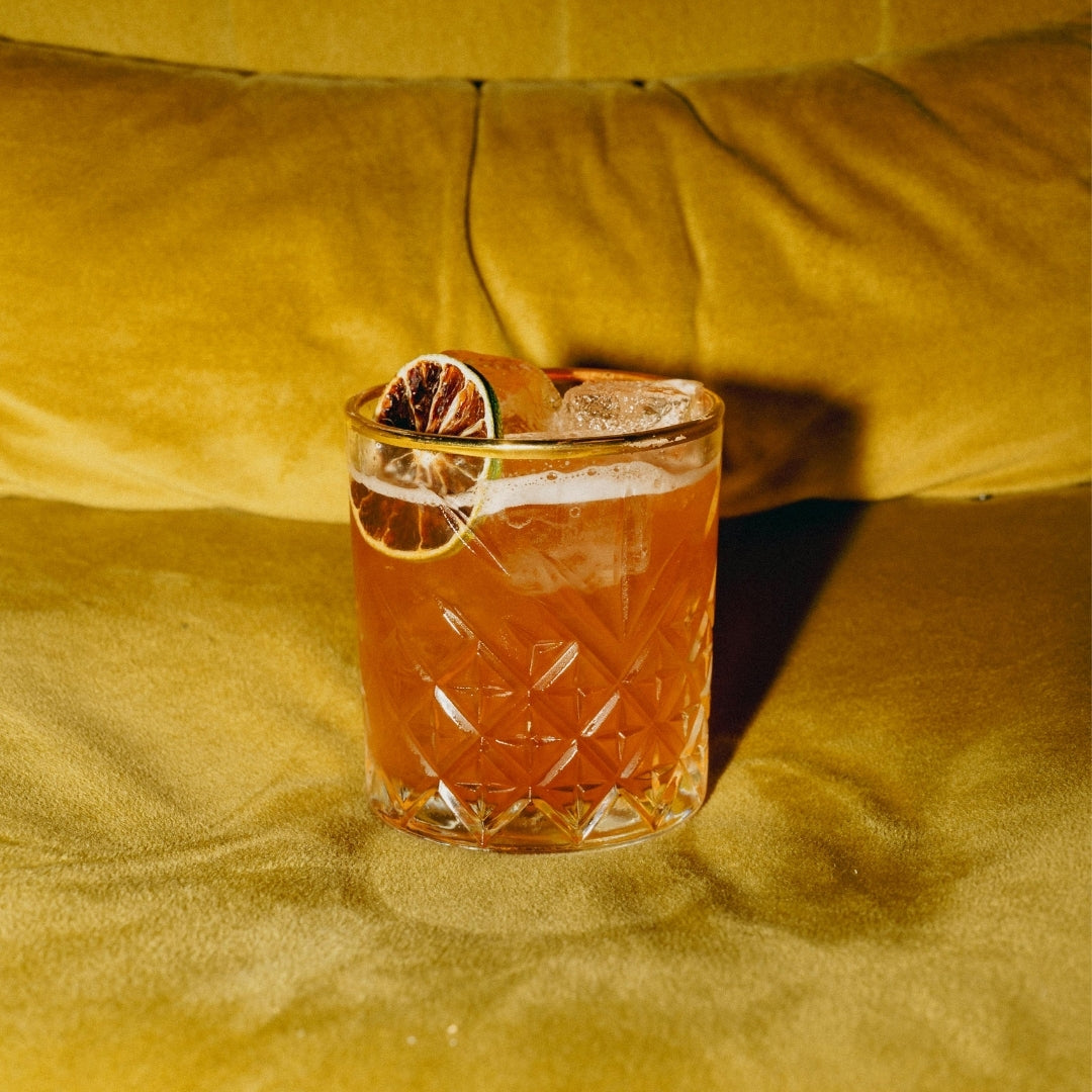 glass gifts, bourbon glass with orange peel on yellow couch