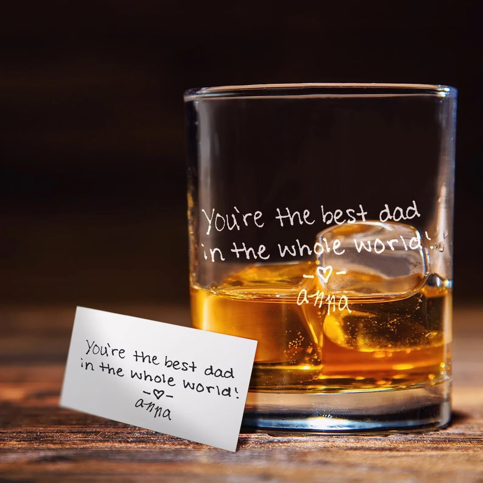 Glass of whiskey with a note on a wooden surface