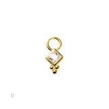 Gold charm with a square cut gemstone on a white background