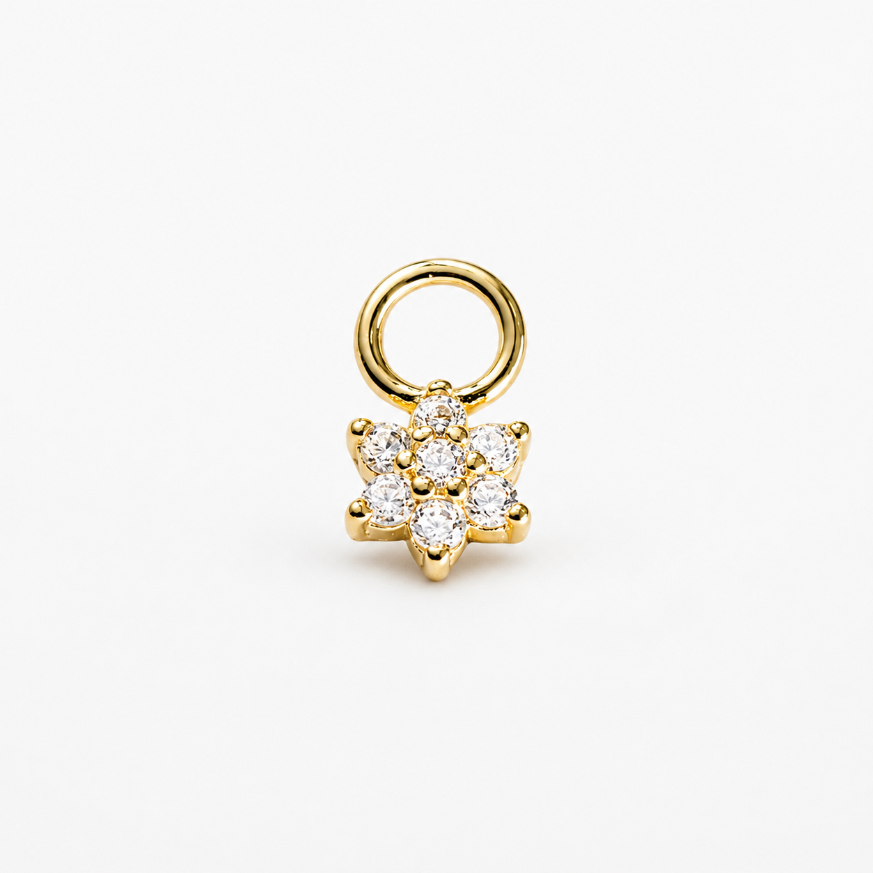 A gold flower-shaped charm with a circular ring attachment, featuring clear round-cut gemstones, set against a plain white background.