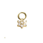 Gold charm with star design and embedded stones on a white background