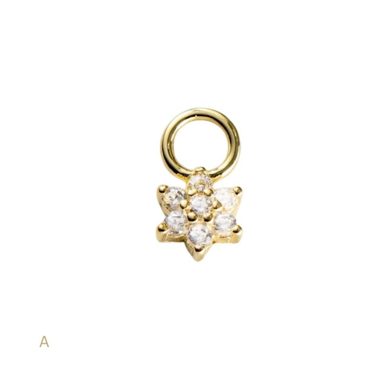 Gold charm with star design and embedded stones on a white background