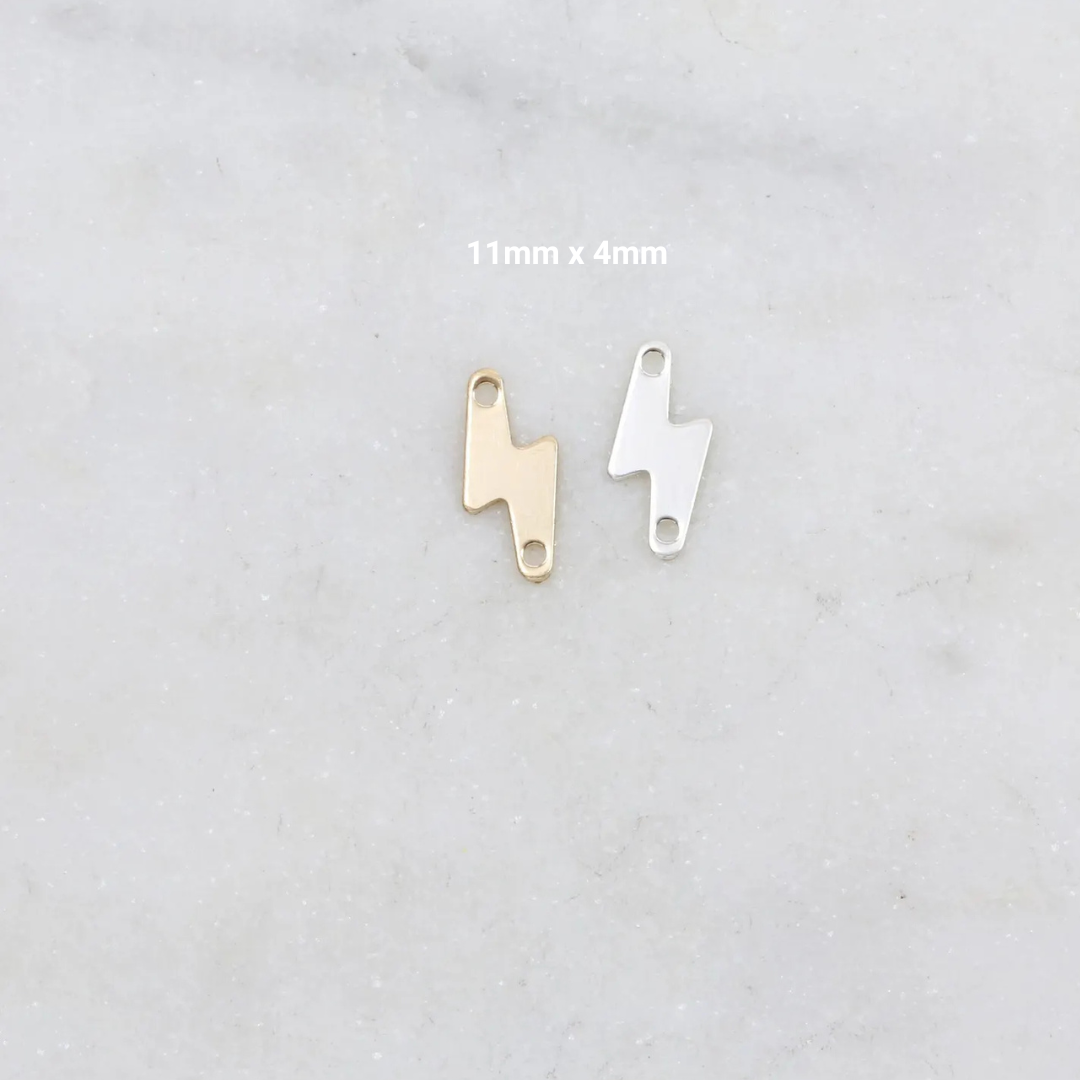 Gold and silver lightning bolt-shaped charms on a light gray background