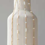 A close-up image of a bracelet with interlocked gold chains against a light background.