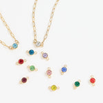 Gold necklaces with colorful gemstone pendants on a white background