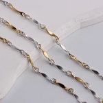 Two gold and silver chain necklaces on a light gray background