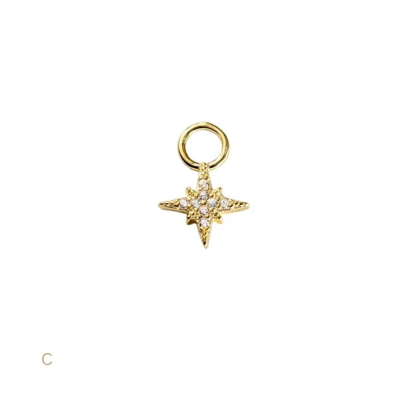 Gold star-shaped pendant with embedded stones on a white background