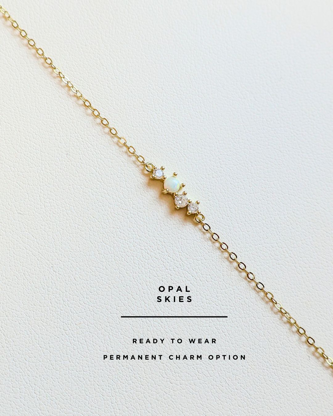 Gold permanent bracelet with opal stones on a white background, branded 'Opal Skies'.