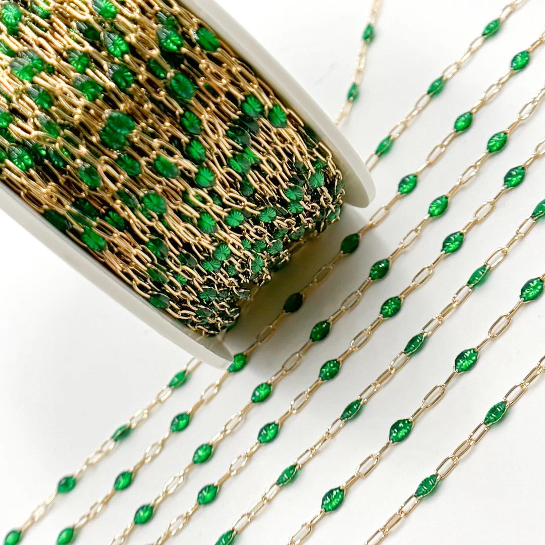 Gold chain with green beads on a white background