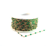 Gold chain with green beads on a white background