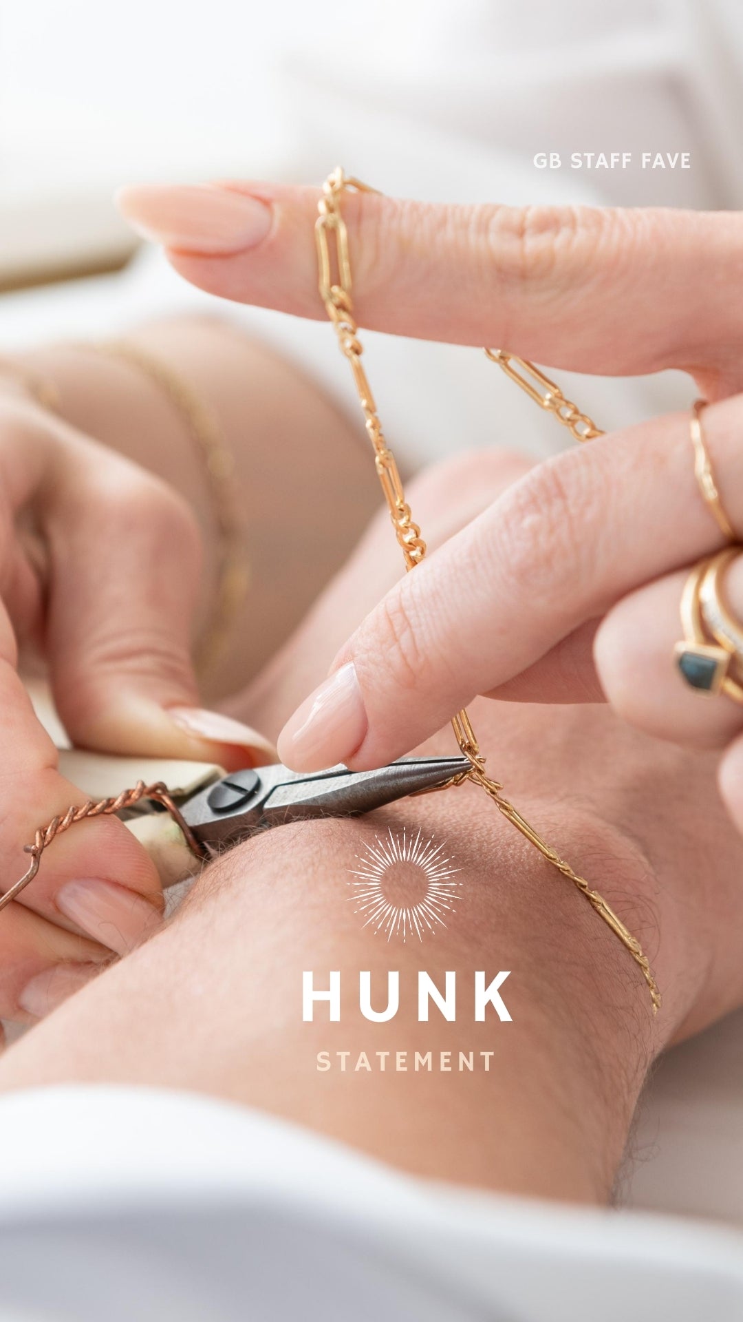 A close-up image of a bracelet with interlocked gold chains against a light background.