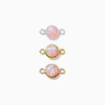 Three opal gemstone connectors with gold settings on a white background
