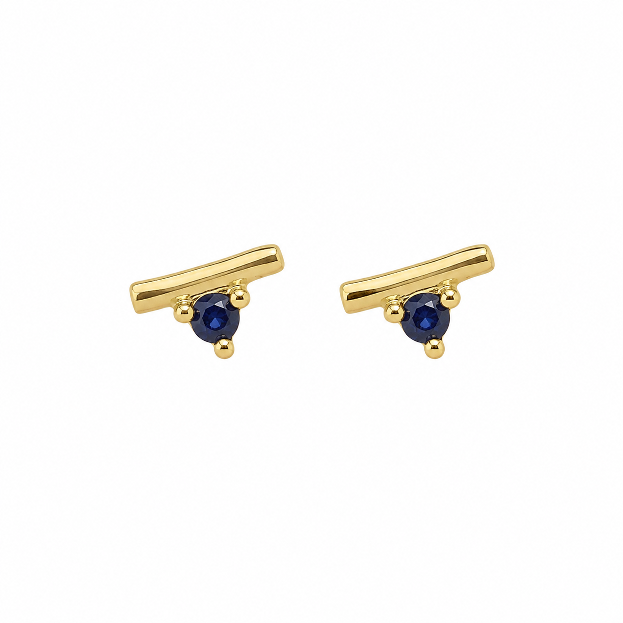 A pair of gold-toned stud earrings with a curved bar design and a small round dark blue gemstone at the center, set against a plain white background.