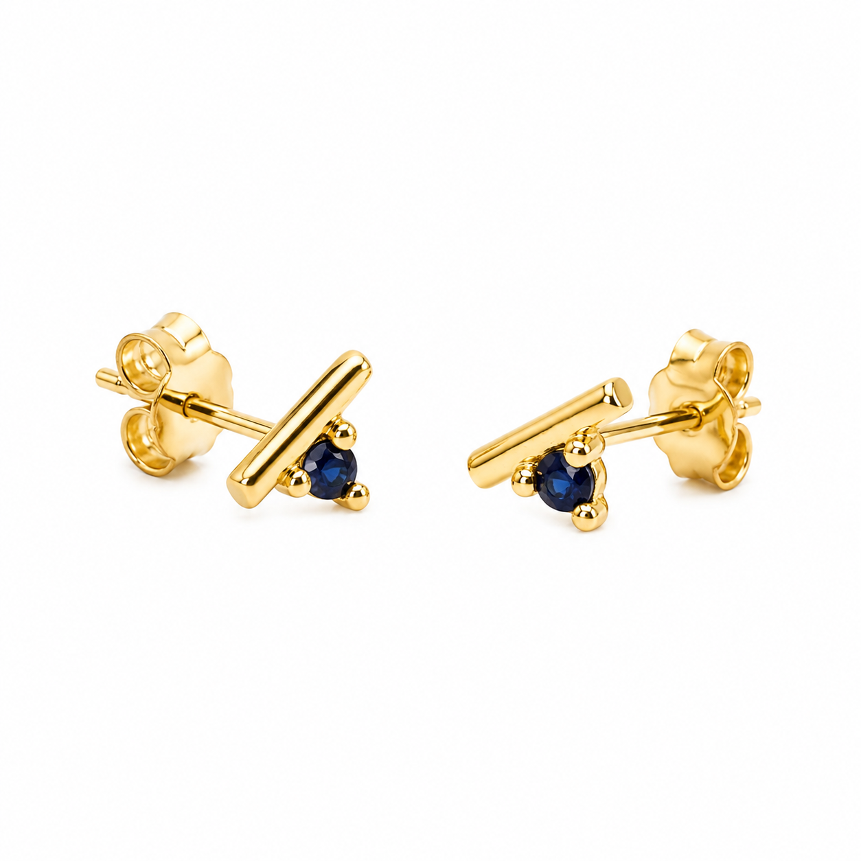A pair of gold stud earrings with a small triangular dark blue gemstone, shown on a clean white background.