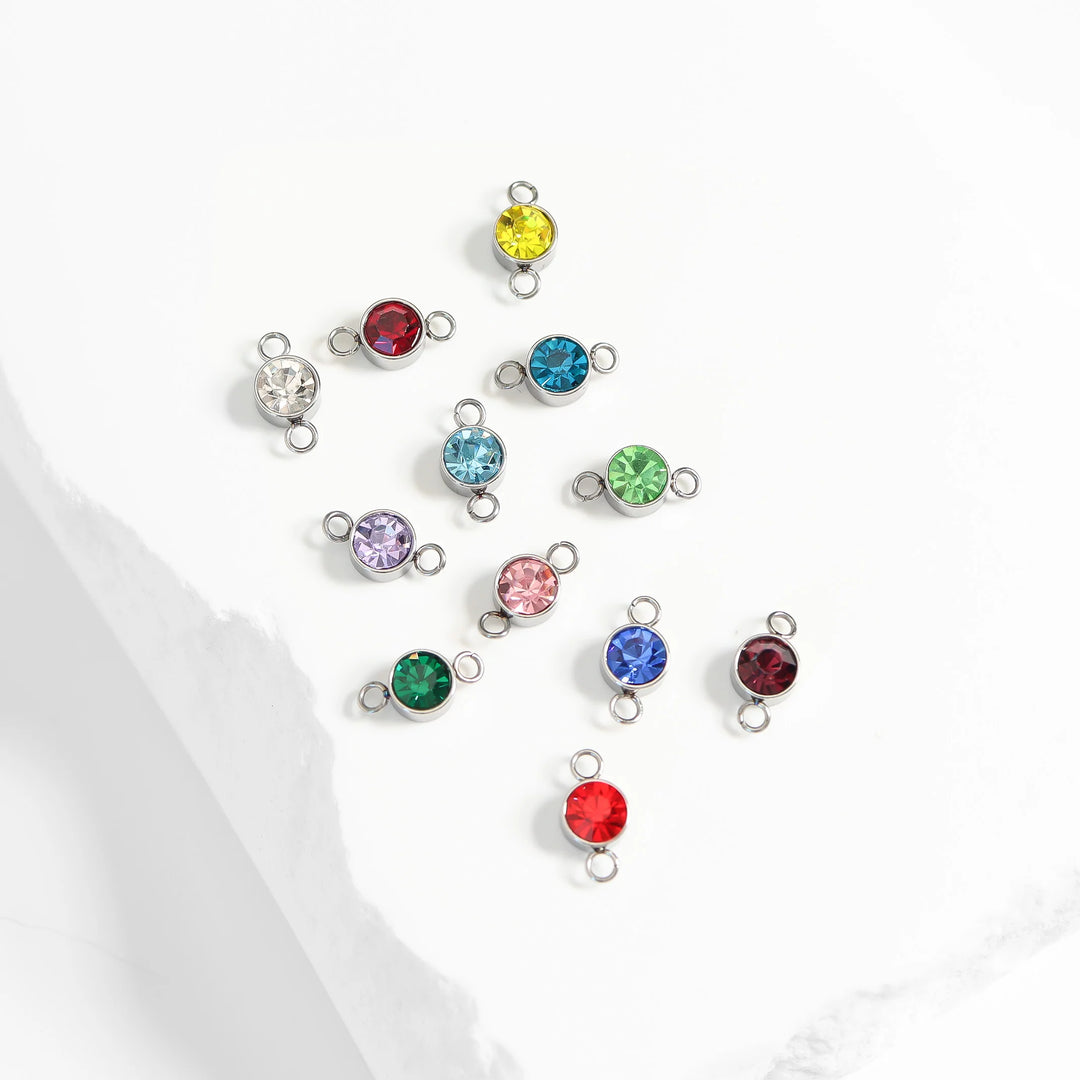 Assorted colorful gemstone connectors on a white background