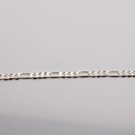 A silver-colored Hermes 925 bracelet laid out on a plain surface.