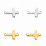 Four small cross-shaped jewelry findings arranged in a 2x2 grid on a white background, showing two silver finishes and two gold finishes, including smooth and hammered textures.