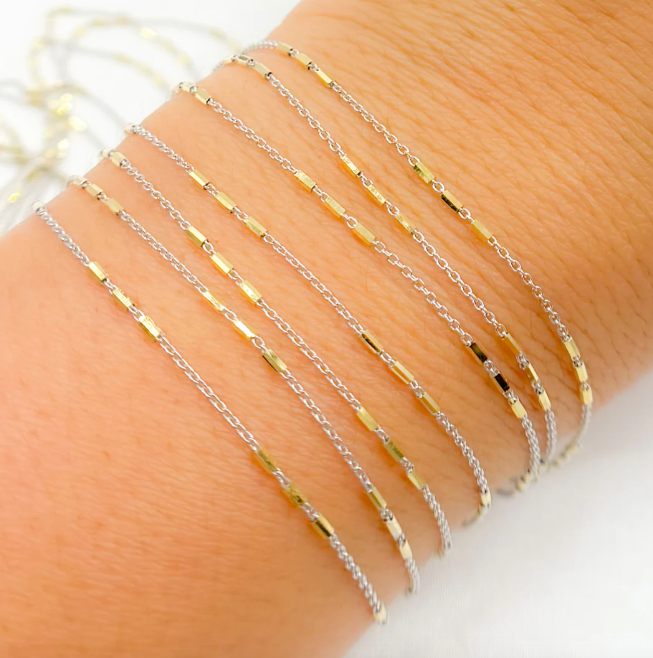 Cosmo is 3 gold bars on white gold bracelet chain