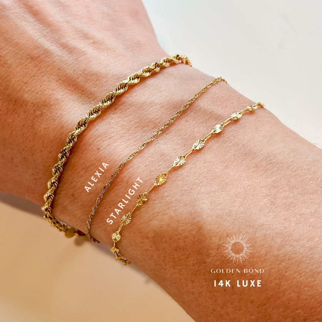 A close-up image of a bracelet with interlocked gold chains against a light background.