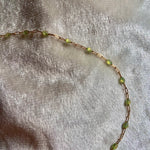 Necklace with green beads on a textured beige background