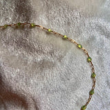 Necklace with green beads on a textured beige background