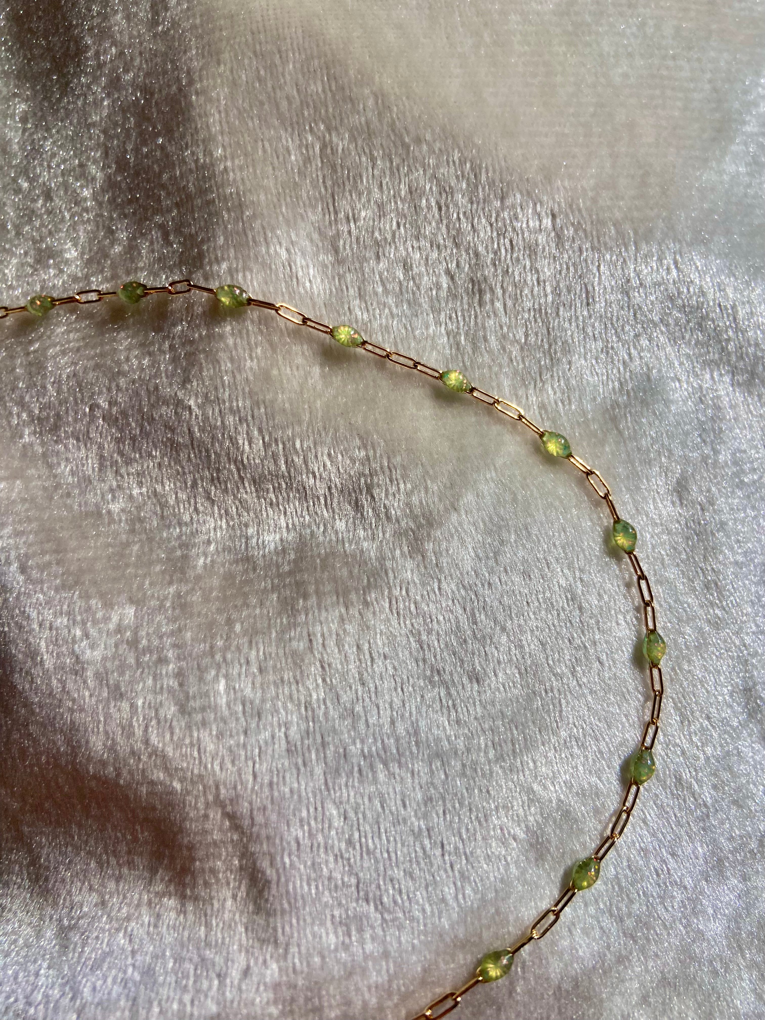 Necklace with green beads on a textured beige background