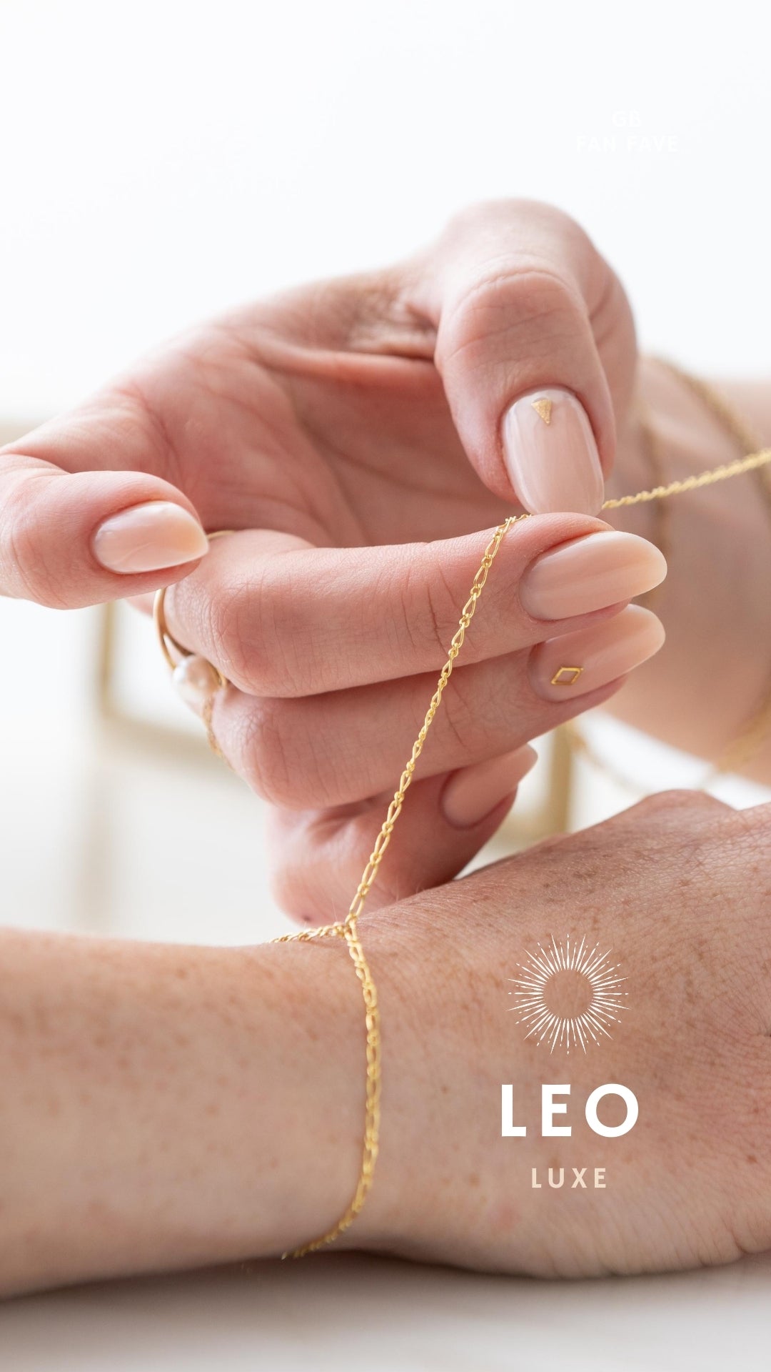 A close-up image of a bracelet with interlocked gold chains against a light background.